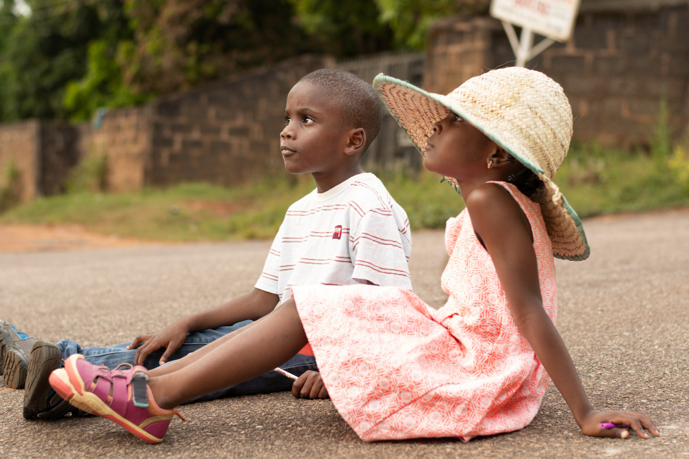 Nigerian caregiver showing a cup and speaking slowly to her autistic child to encourage communication